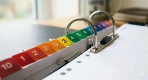 High-detail view of A4 numbered dividers 1-31 showing the universal multi-hole punching designed to fit standard British lever arch files and binders.