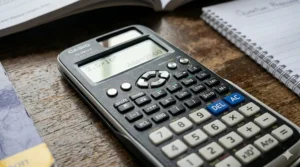 Close-up shot of the front cover of an AQA A-level physics revision guide on a wooden desk.