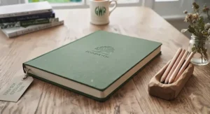 A sustainable, eco-friendly A5 sketchbook made from recycled materials, resting on a wooden surface.