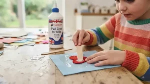Demonstrating how children can easily spread PVA glue using a brush for school craft projects.