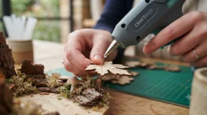 Close-up of a precision-tip glue gun for crafts being used for delicate paper-mache modelling.