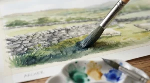 Artist using a fine-tip brush from a cheap paint brush set for watercolour painting.